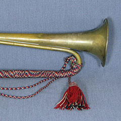 Clairon orné de fils tressés rouge, noir et beige