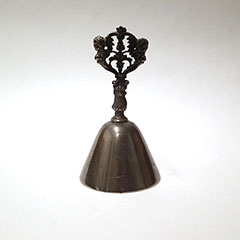 Cloche liturgique fait de métal dont la poignée est taillée en forme de feuilles.