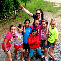 Un groupe d'enfants pose en compagnie de leur animatrice de camp de vacances.