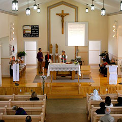 Un prêtre célèbre l'Eucharistie dans une église moderne, en 2014.