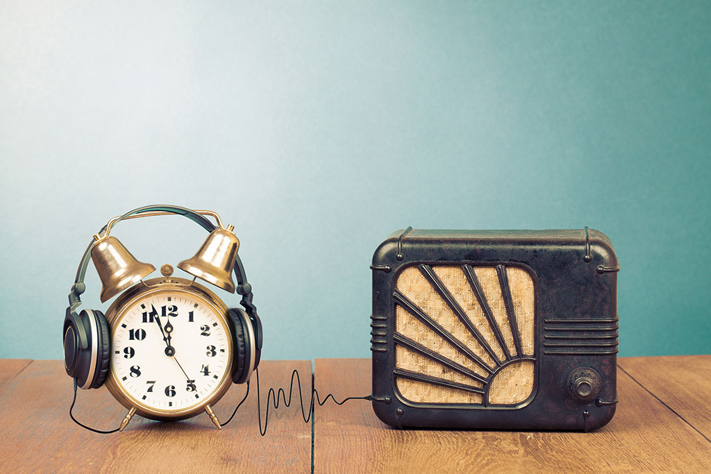 Réveil-matin, écouteurs et récepteur radio sur table
